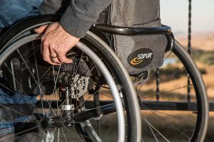Close up shot of man's hand on wheel of a wheelchair